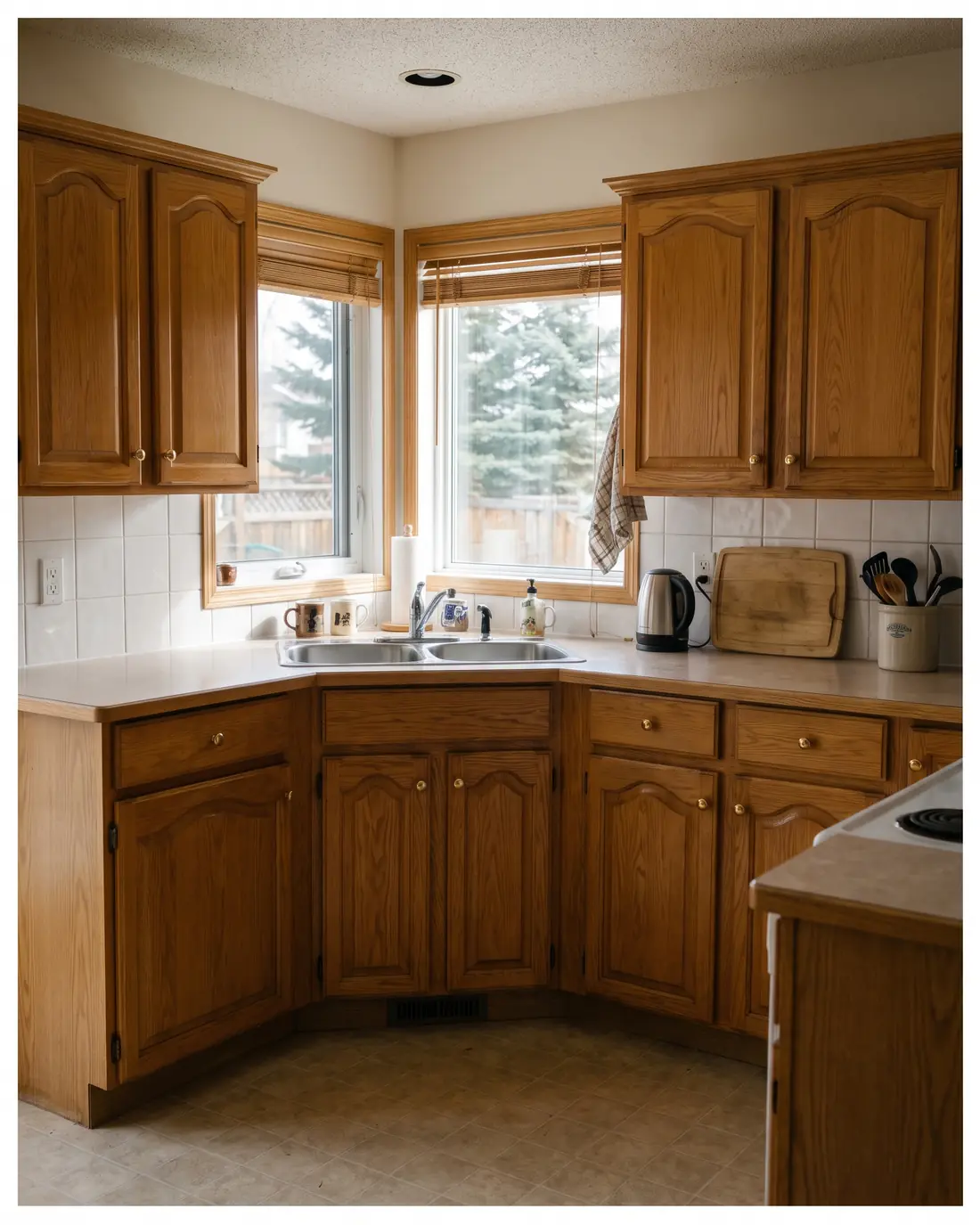 The same kitchen with honey oak cabinet doors with arched tops and brass knobs, concept render