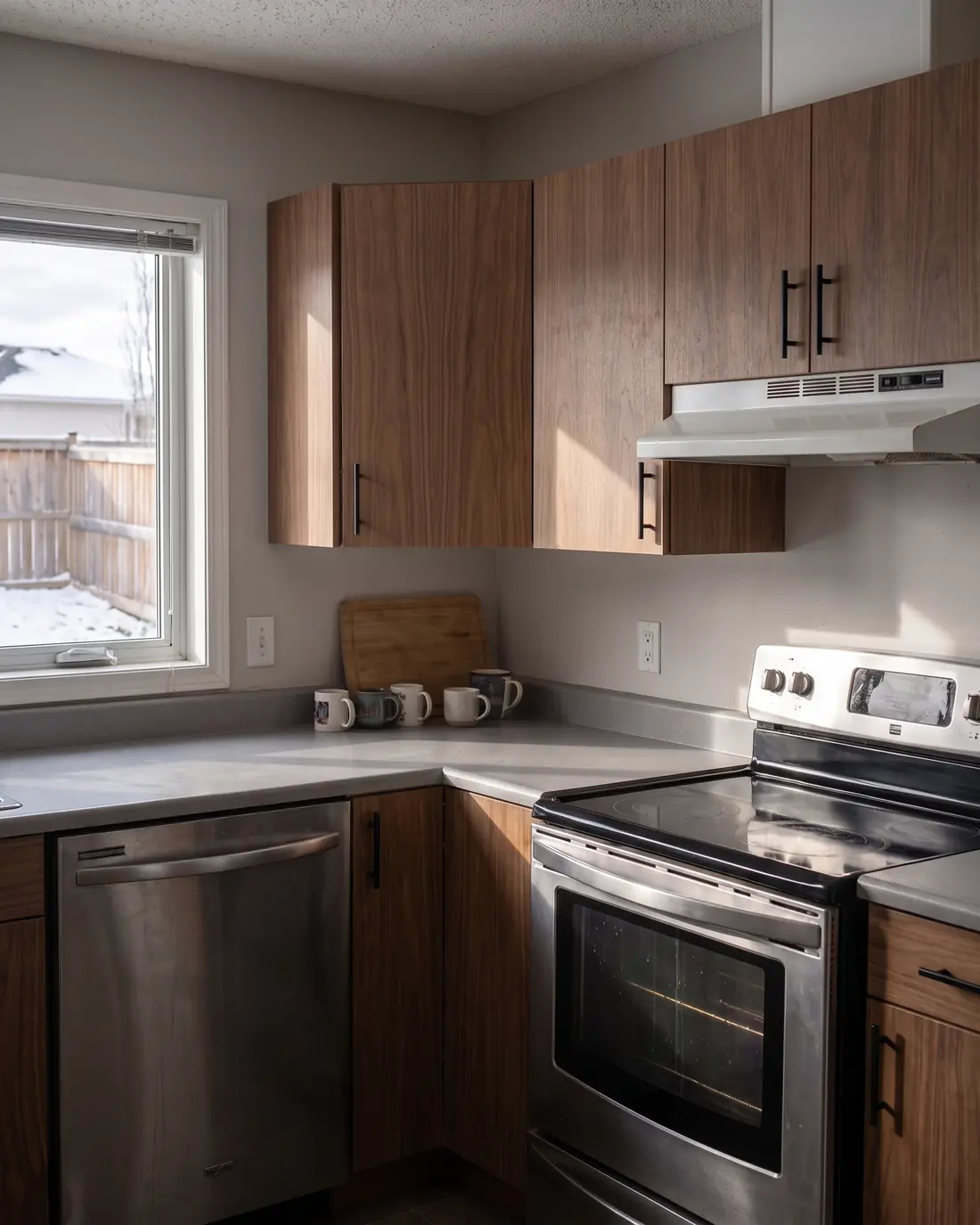 A kitchen refaced with flat walnut veneer doors and black bar pulls, concept render